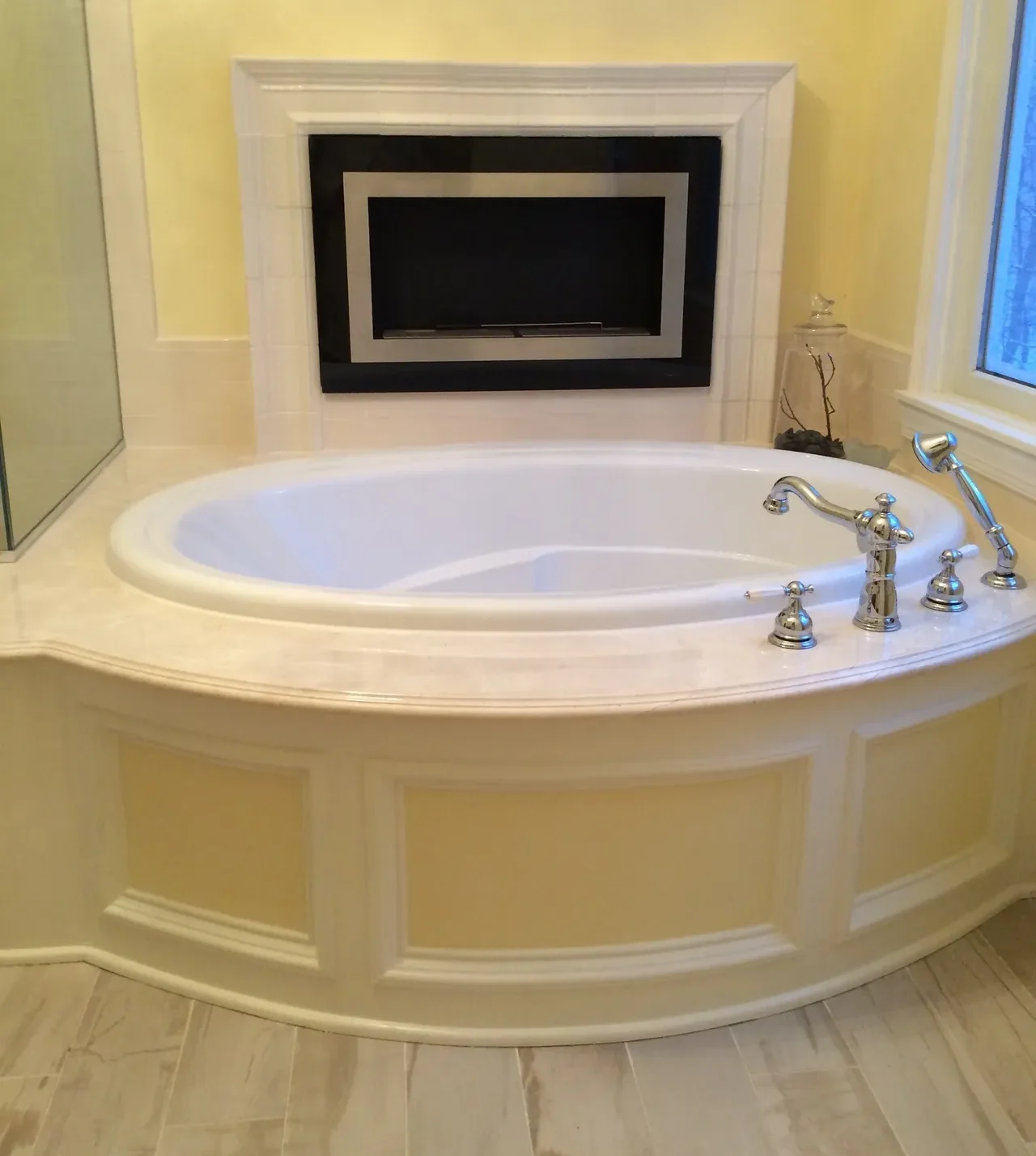 A large white bath tub sitting in the corner of a bathroom.