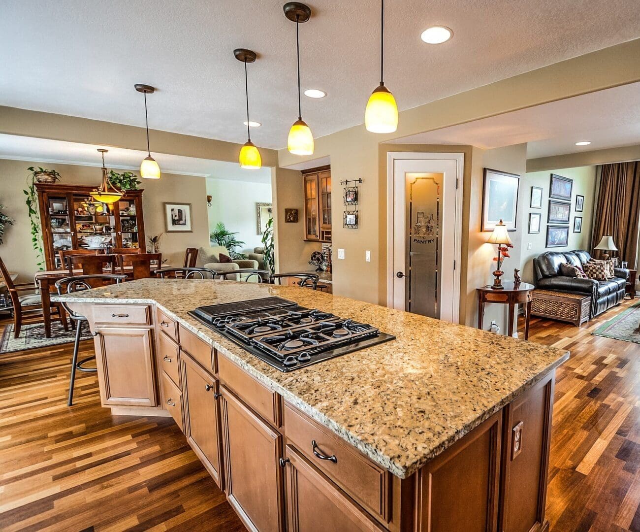 A kitchen with wooden floors and granite counter tops.