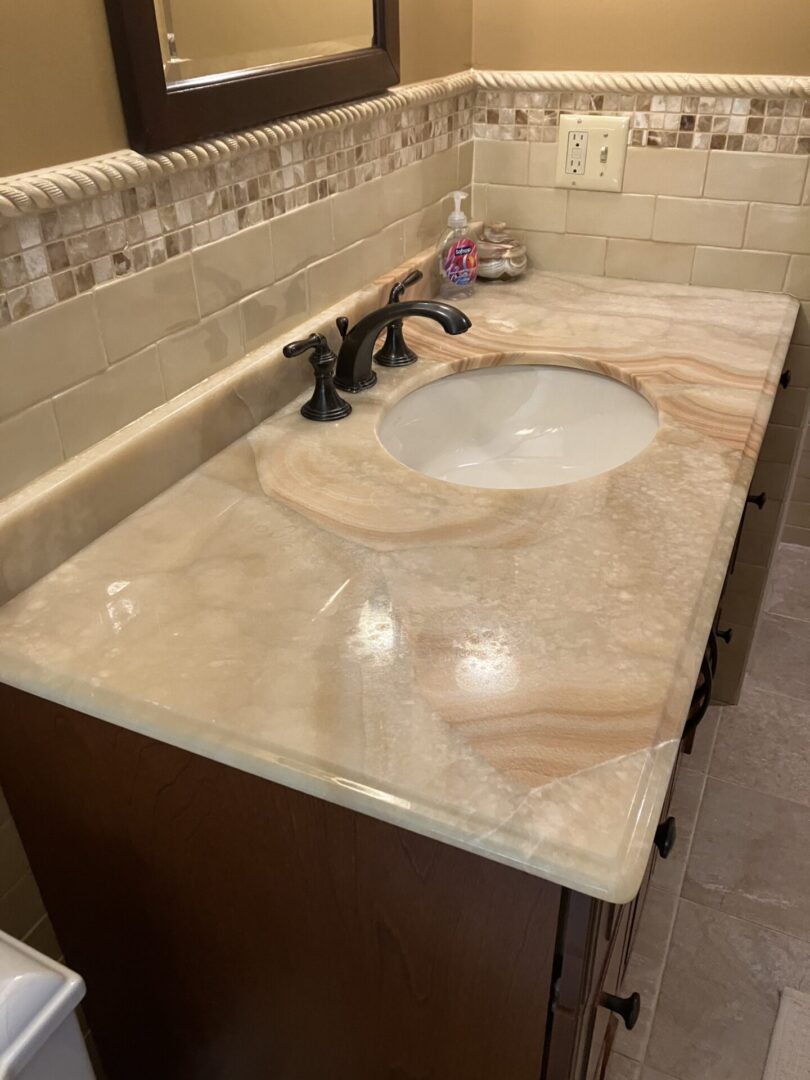 A bathroom with marble counter tops and tile walls.