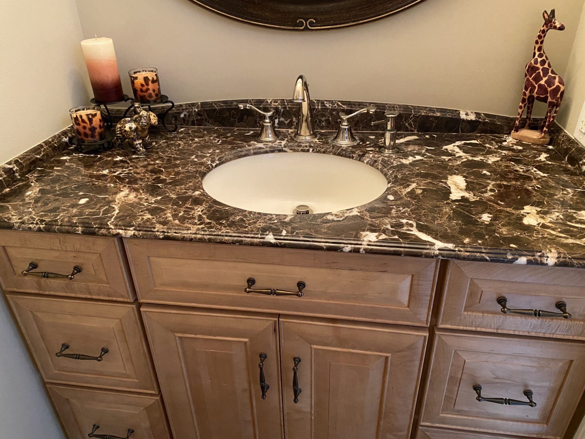 A bathroom with marble counter tops and wooden cabinets.