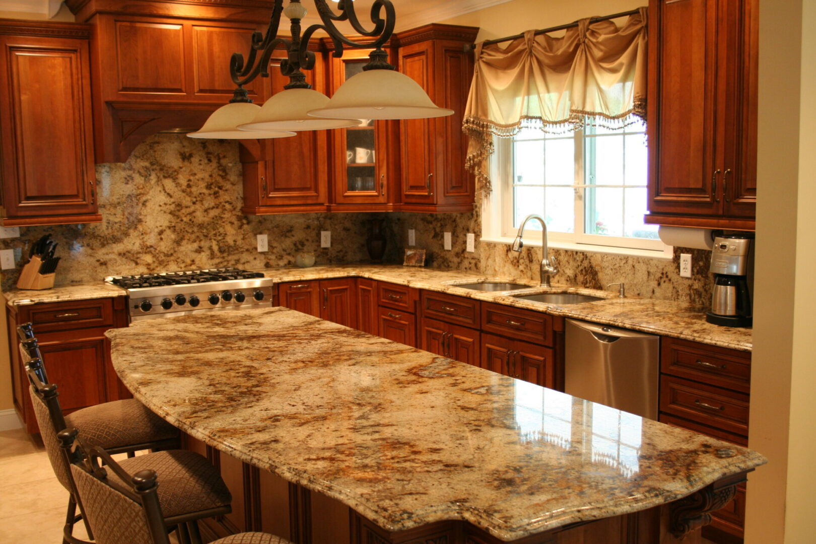 A kitchen with marble counter tops and wooden cabinets.