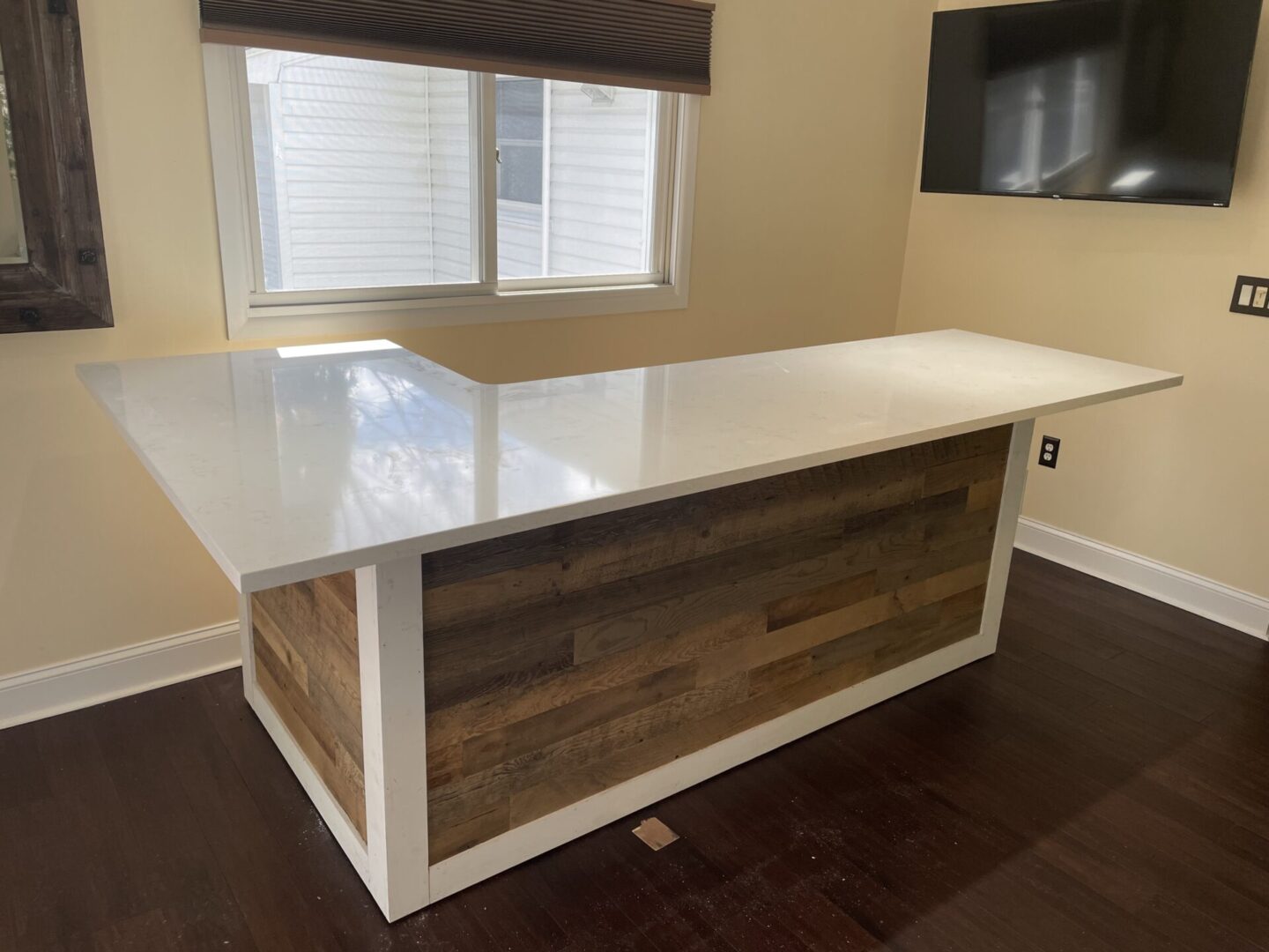 A white counter with wood panels on it.