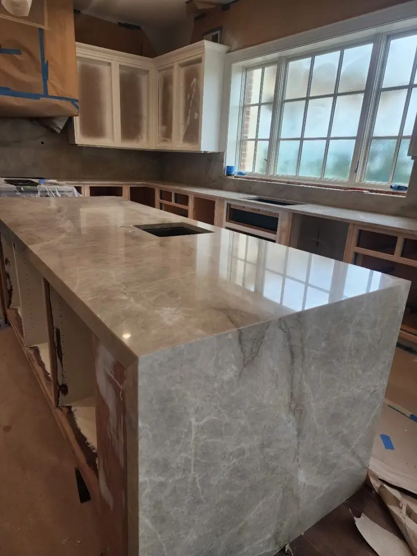 A kitchen with marble counter tops and cabinets.