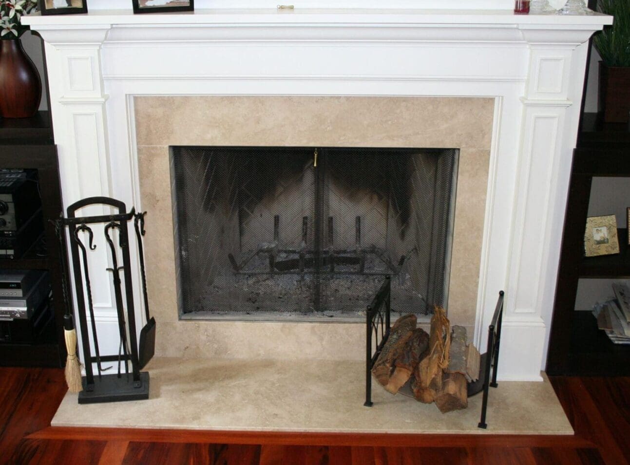 A fireplace with fire place tools and wood.