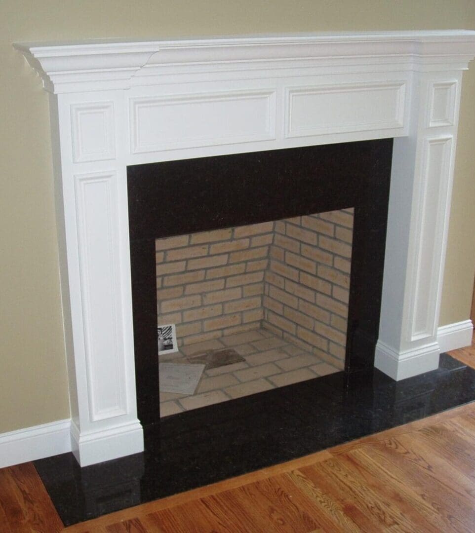 A fireplace with a brick surround and white mantel.