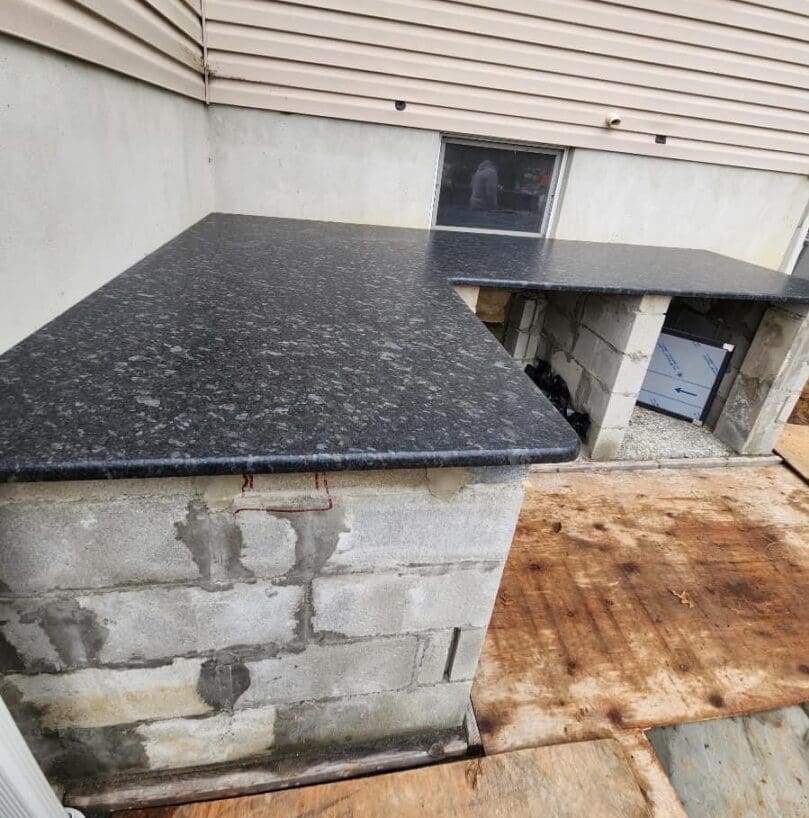 A black counter top sitting on the side of a building.