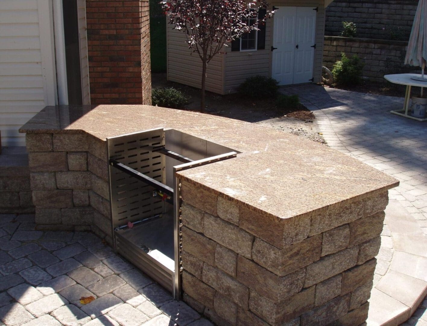 A brick bbq grill with stone walls and an outdoor kitchen.