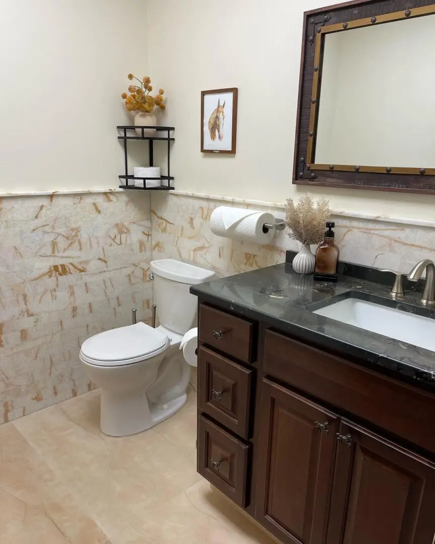 A bathroom with marble tile and wood cabinets.