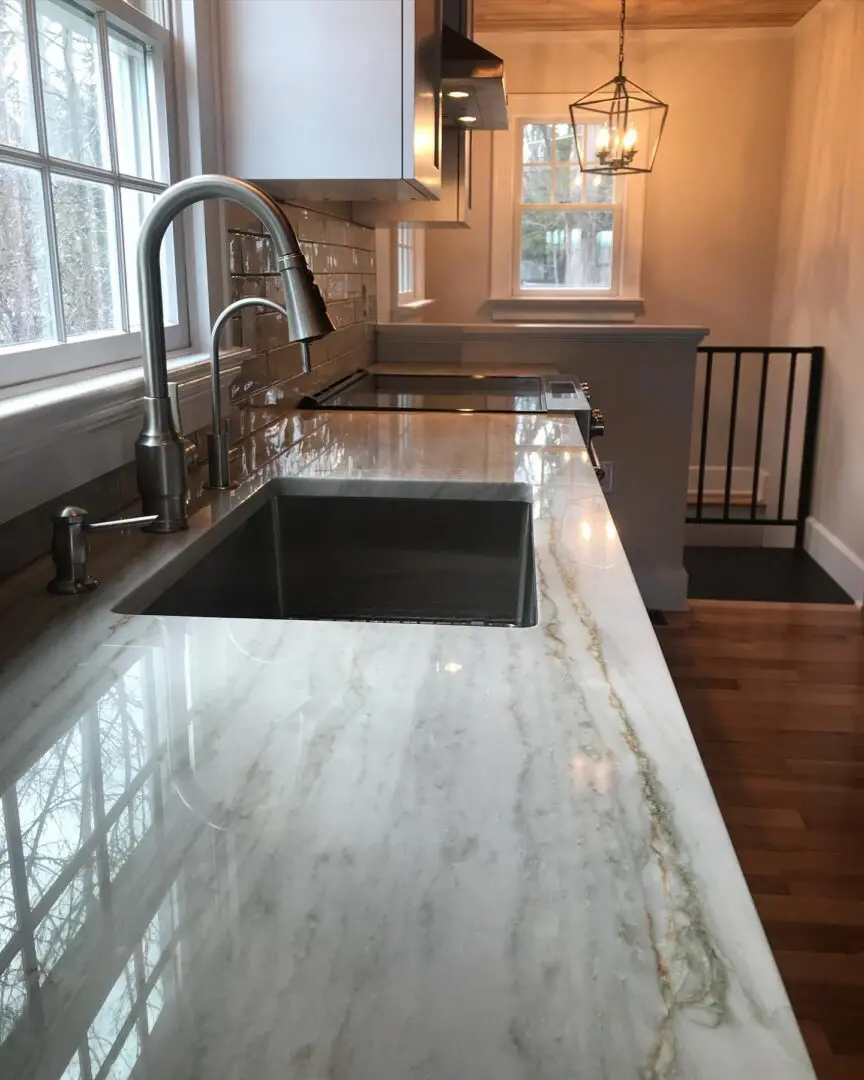 A kitchen with marble counter tops and wooden floors.