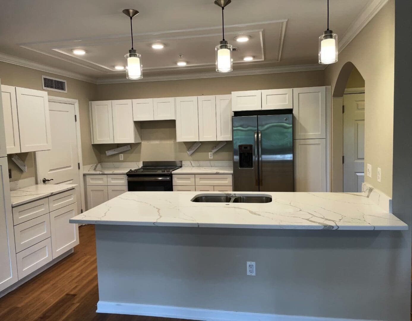 A kitchen with white cabinets and black appliances.