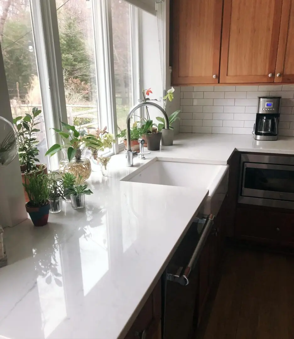 A kitchen with white counters and wooden cabinets.