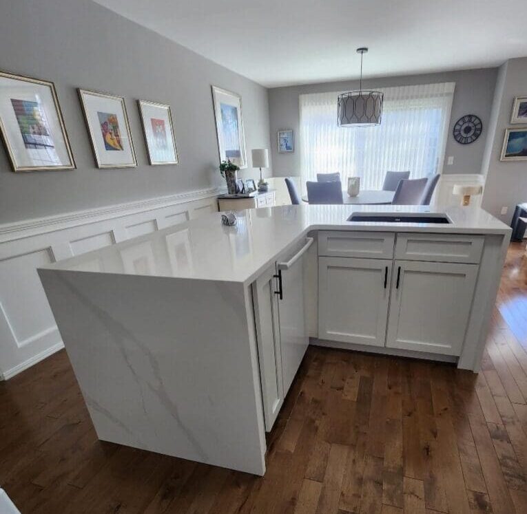 White kitchen island with marble countertop.