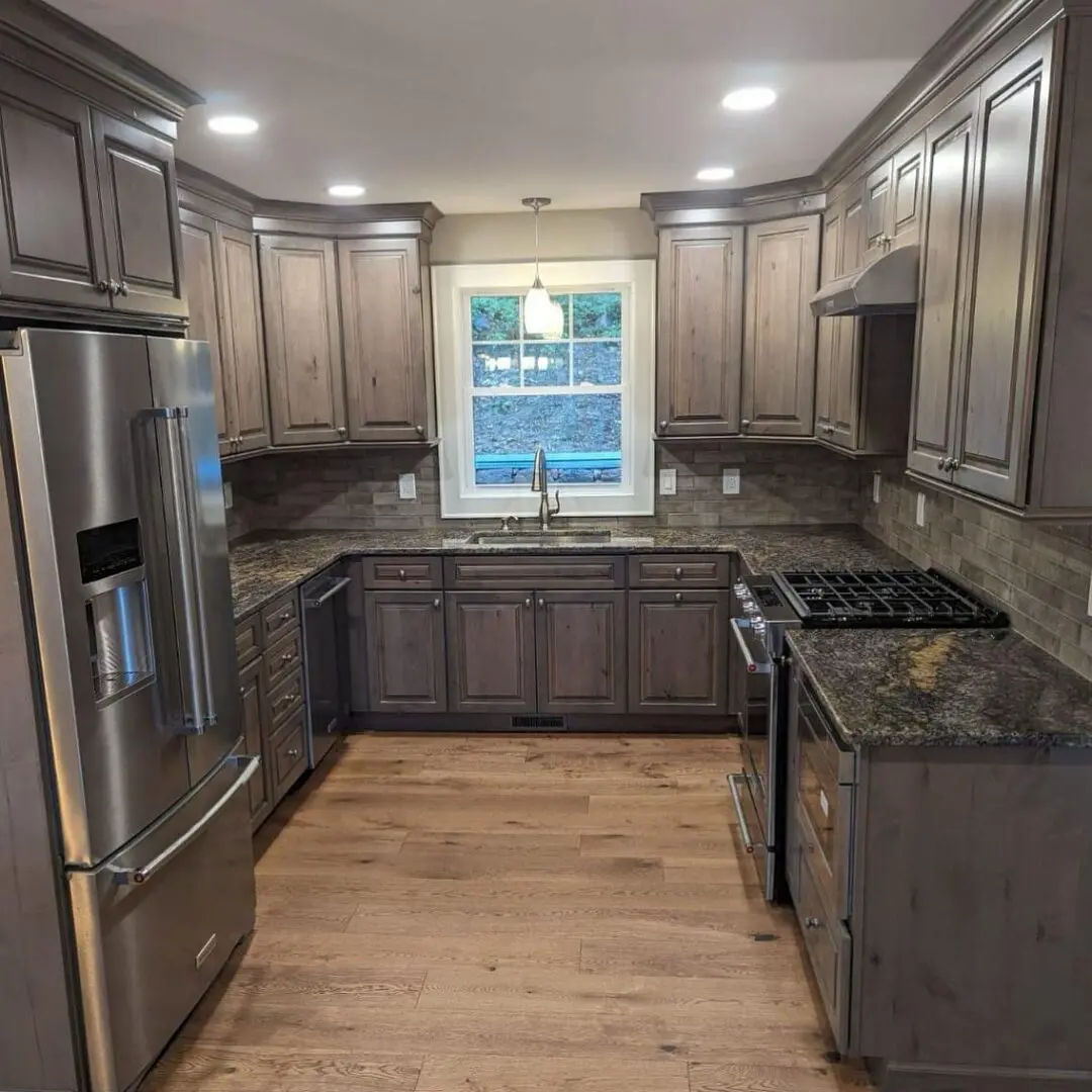 A kitchen with grey cabinets and stainless steel appliances.