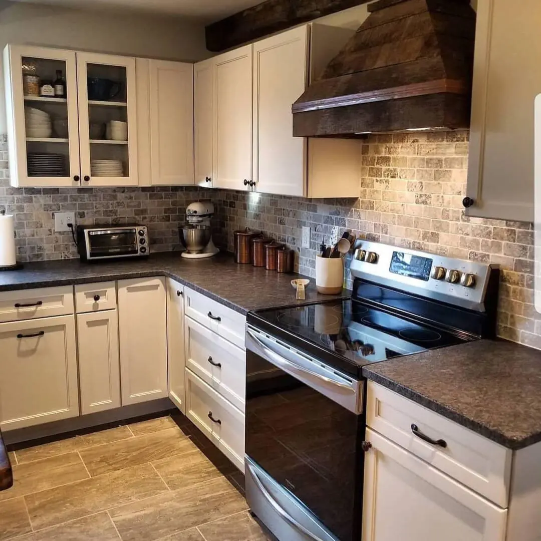 A kitchen with white cabinets and black appliances.