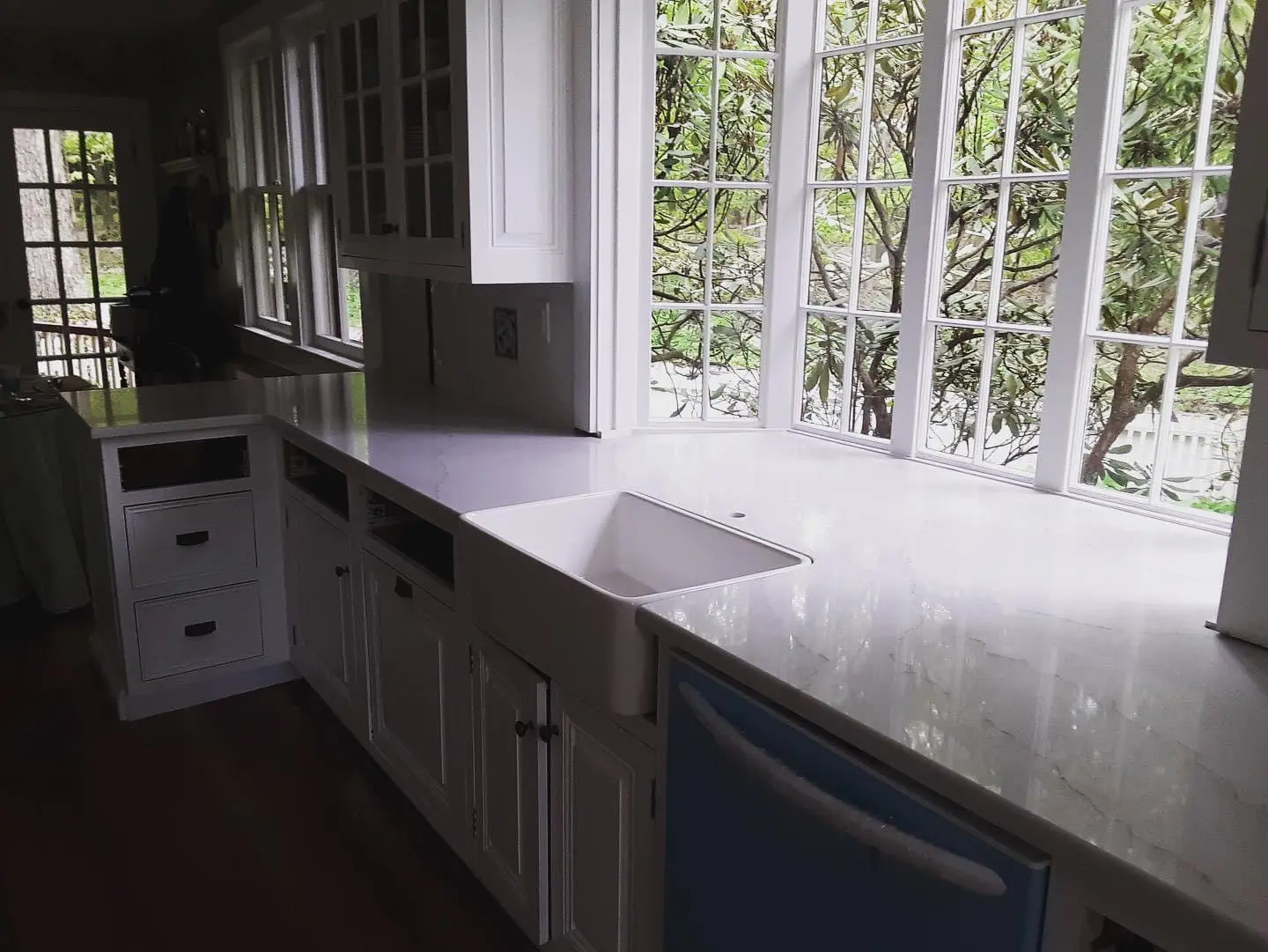 A kitchen with white cabinets and a sink.