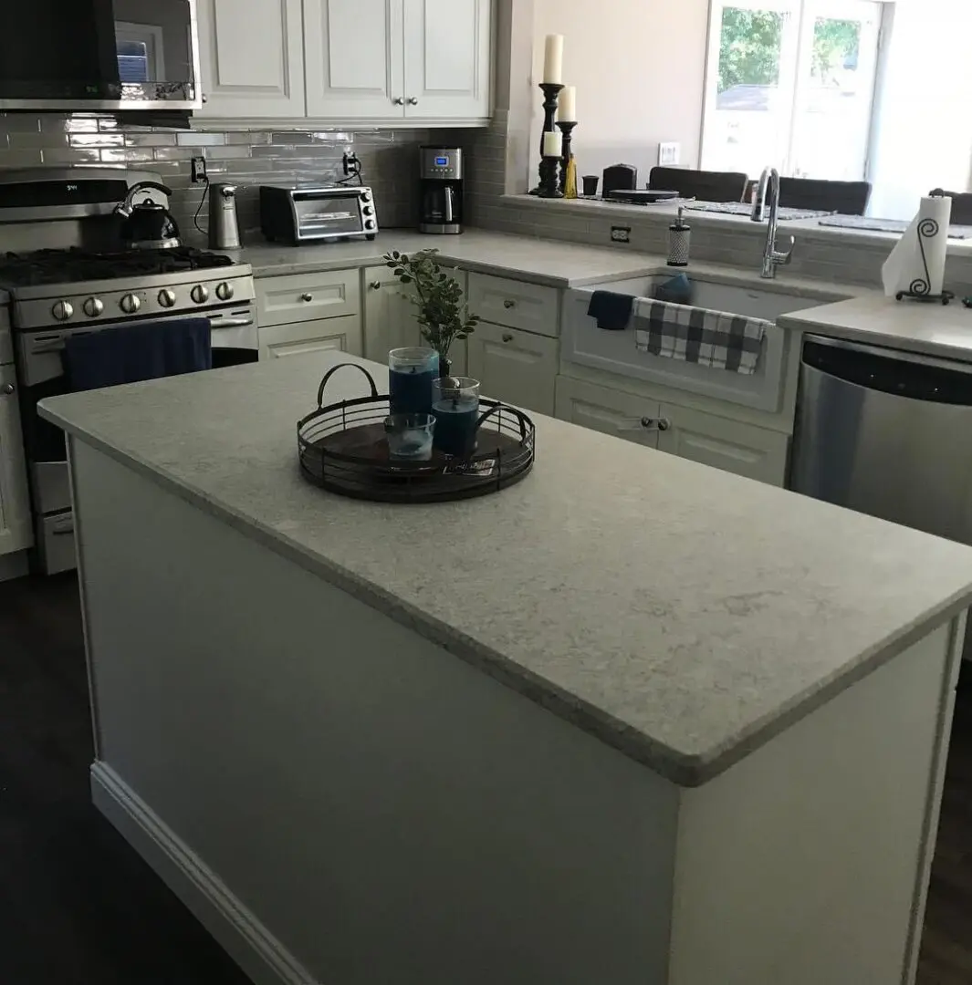 A kitchen with white cabinets and a large island.