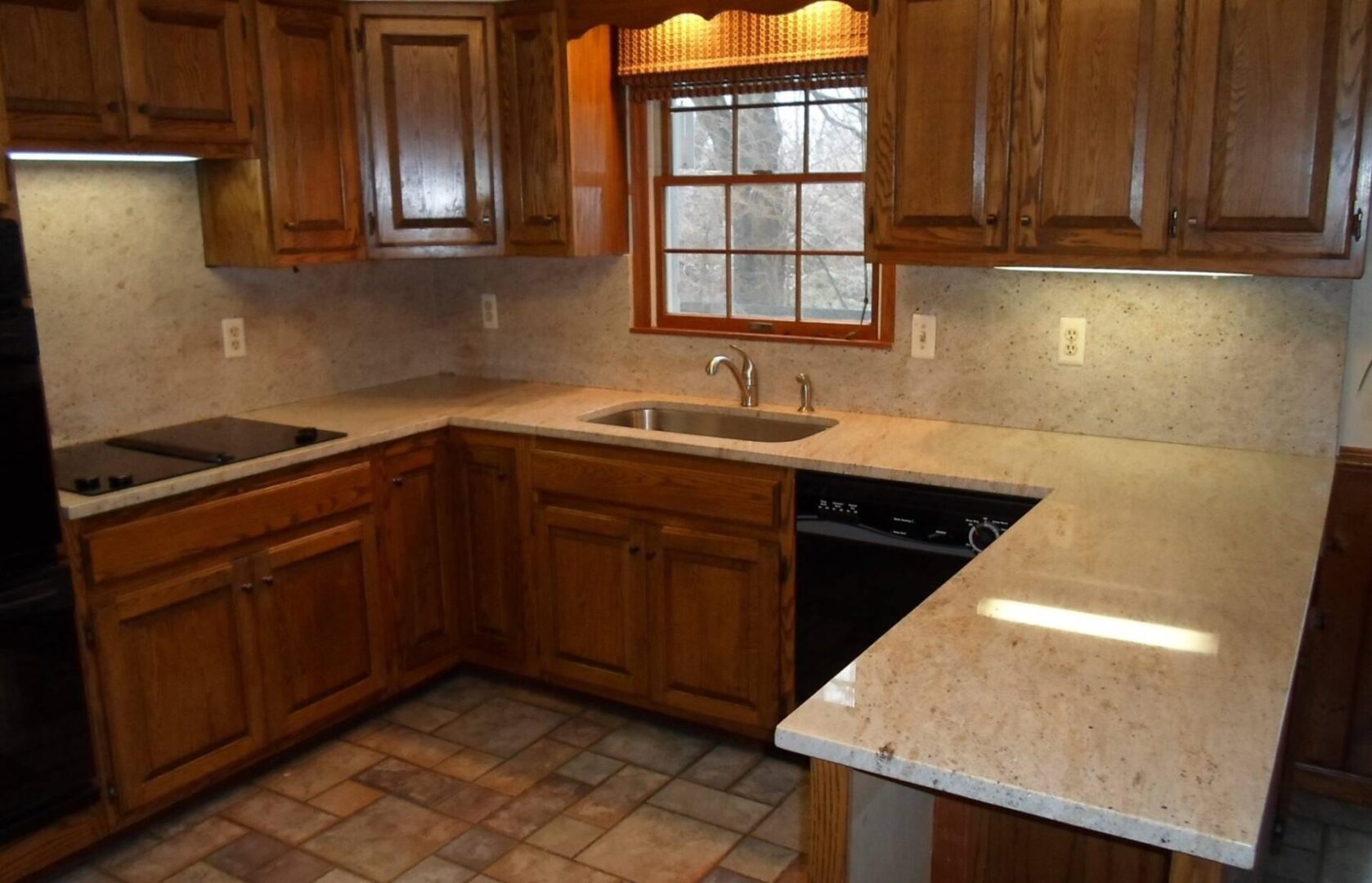 A kitchen with brown cabinets and white counter tops.