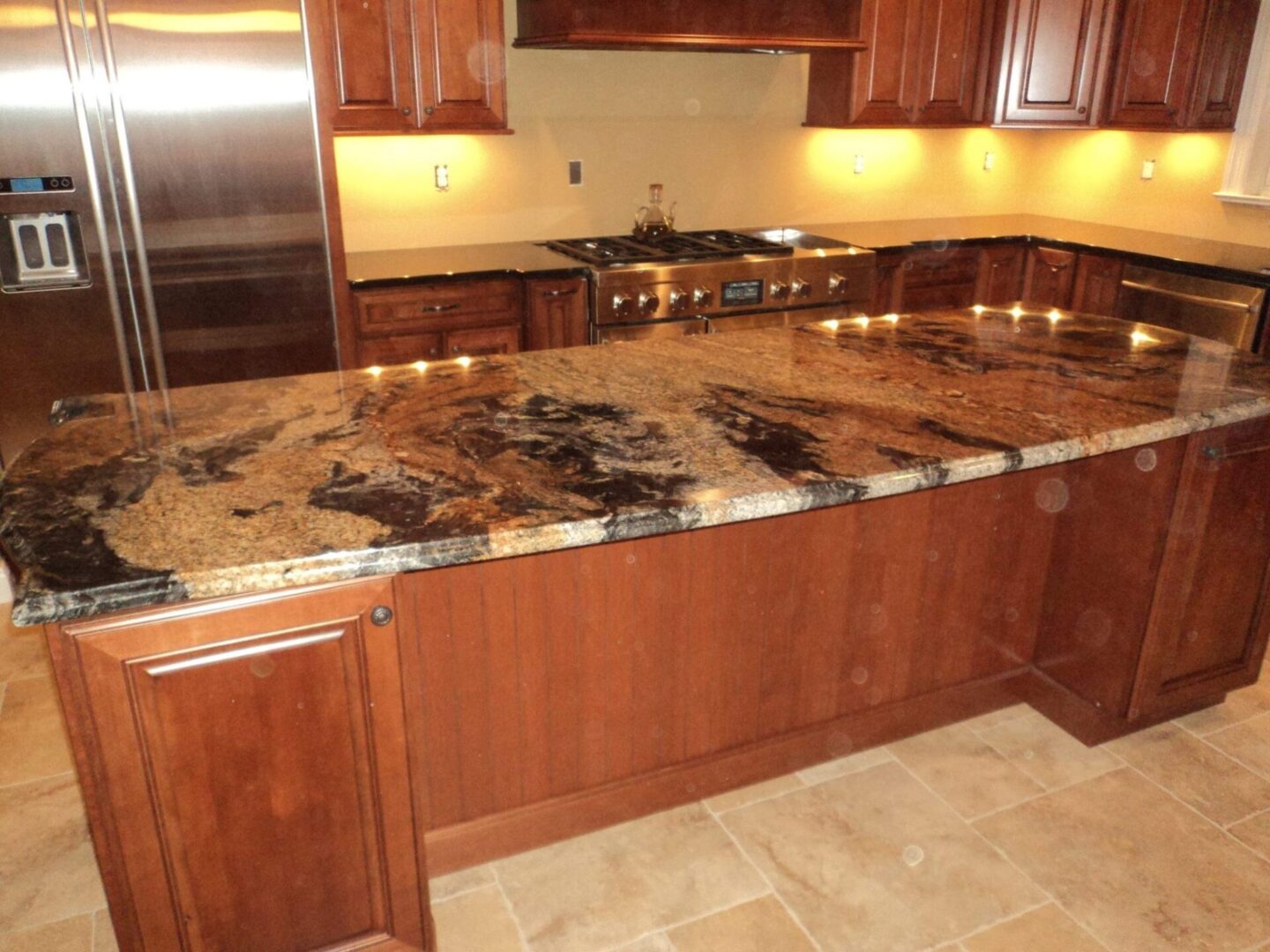 A kitchen with a large island and granite counter tops.