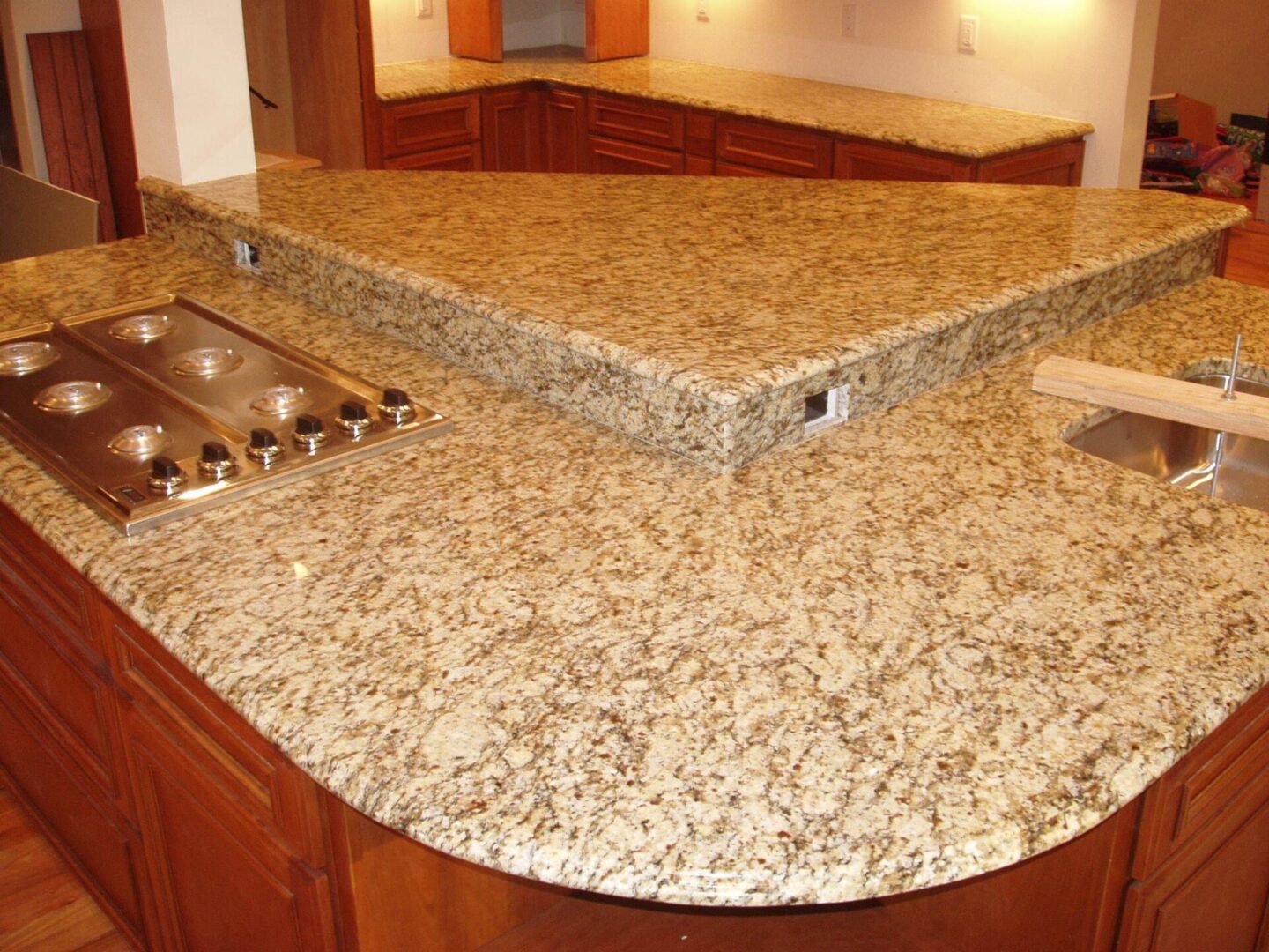 A kitchen with granite counter tops and wooden cabinets.