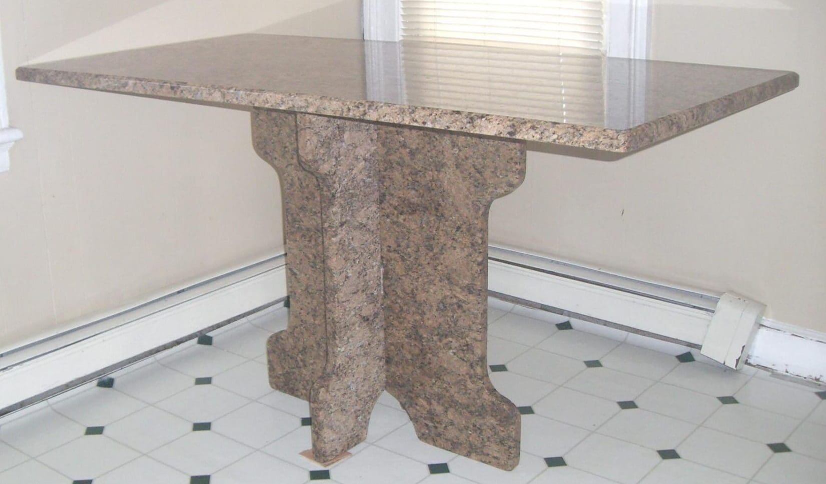 A marble table with a glass top on the floor.