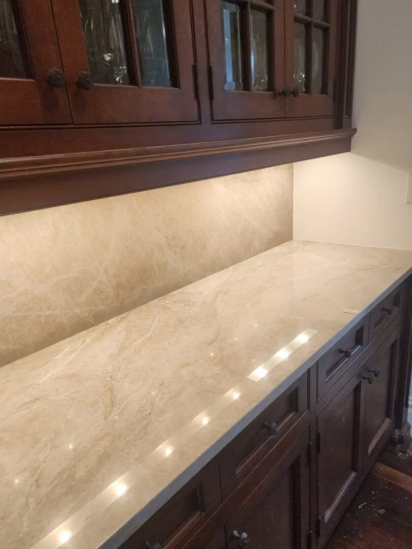 Kitchen counter with wood cabinets and light fixtures.