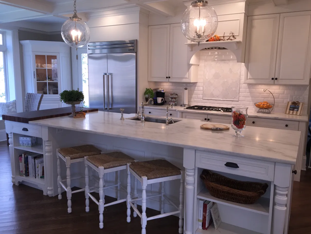 A kitchen with white cabinets and island in it