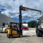 Forklift lifting a sheet of glass.