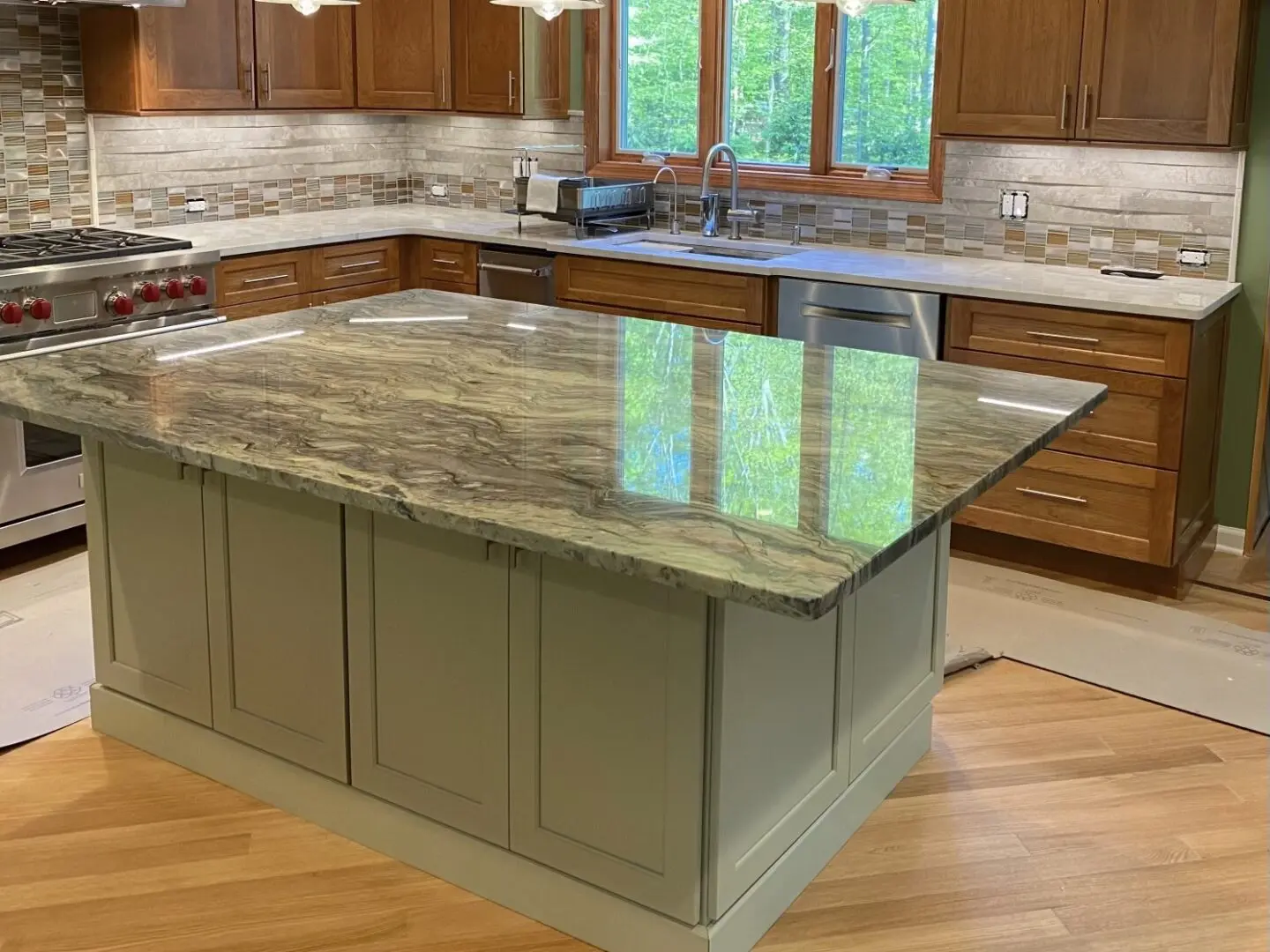 A kitchen with a large island and wooden floors