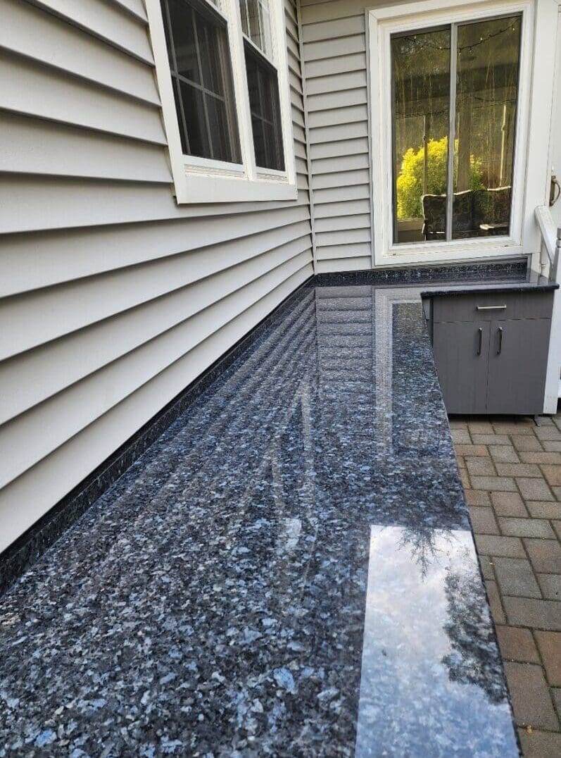 A patio with a blue granite floor and white walls.