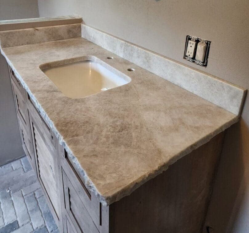 A bathroom with marble counter tops and tile floor.