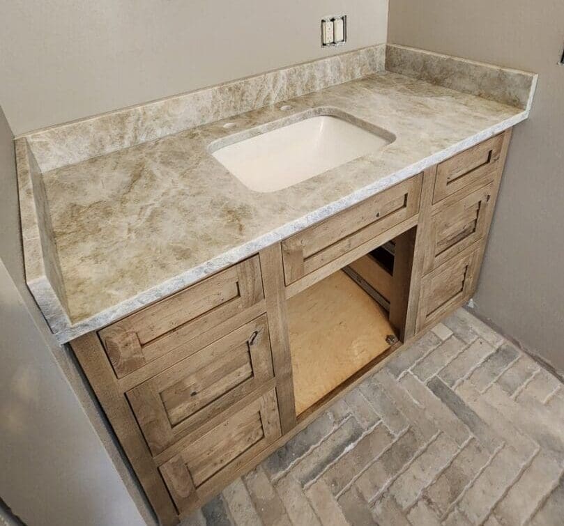 A bathroom with a sink and wooden cabinets