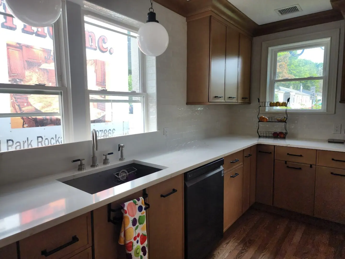 A kitchen with wooden cabinets and white counters.