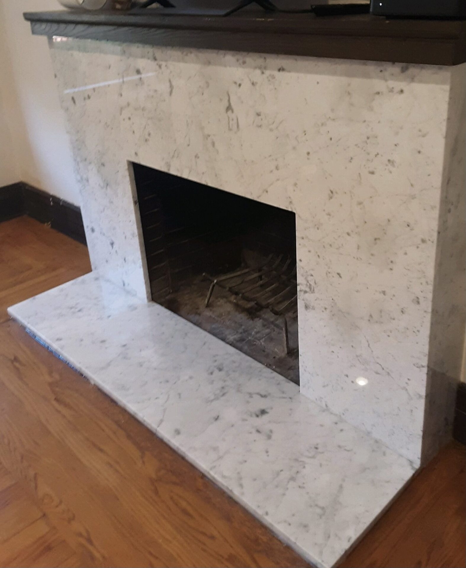 A fireplace with marble surround and hearth in the corner.