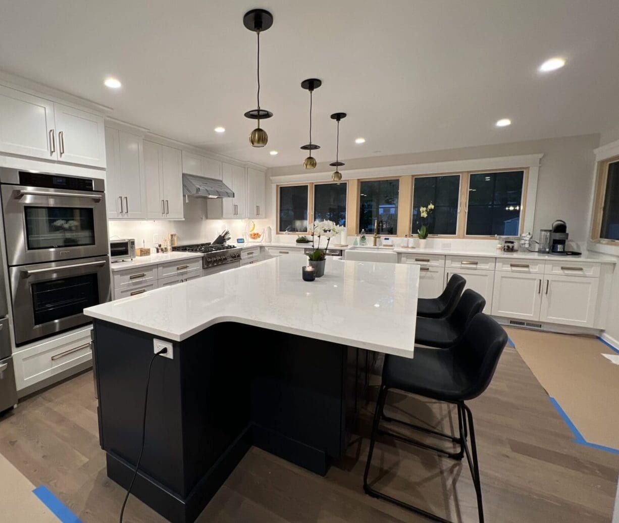 A large kitchen with an island and white cabinets.