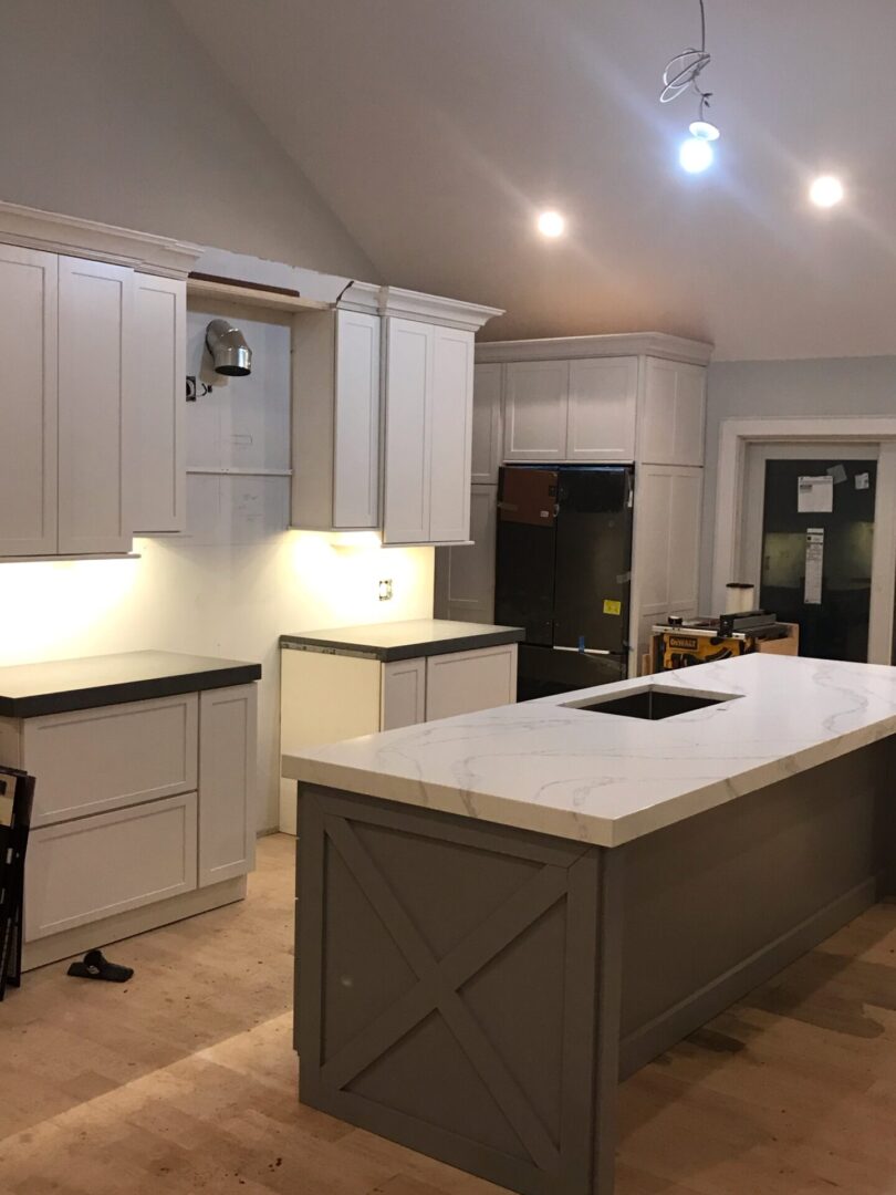 A kitchen with white cabinets and black appliances.