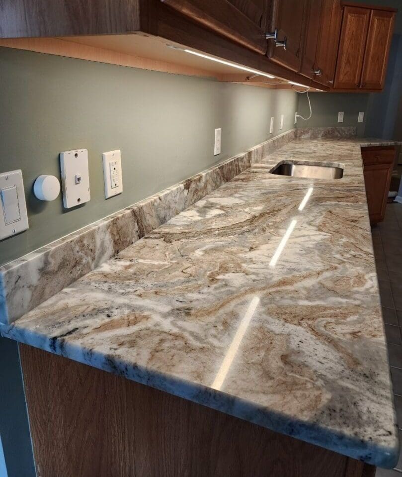 A marble counter top with a sink and cabinets.