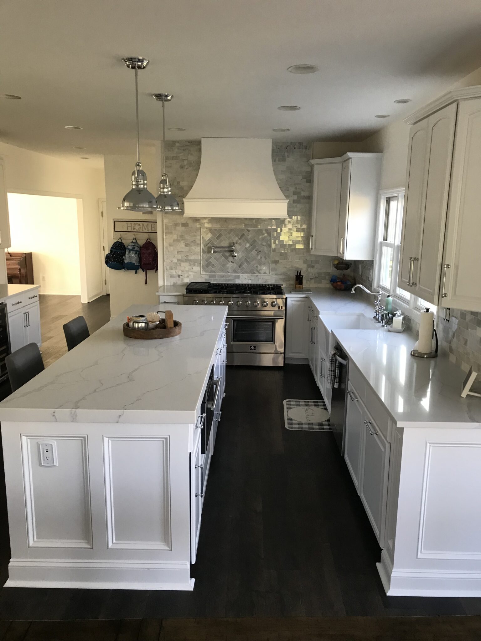 A kitchen with white cabinets and black floor