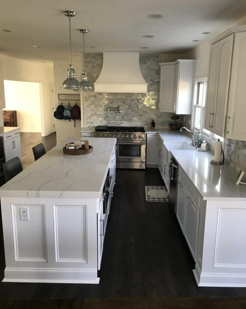 A kitchen with white cabinets and black floor