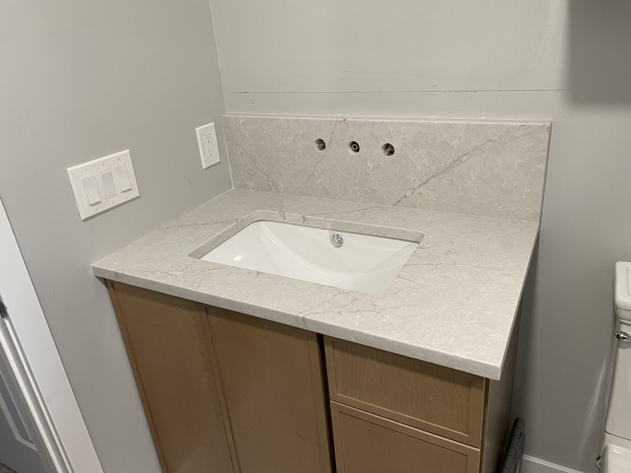 White bathroom vanity with sink and countertop.