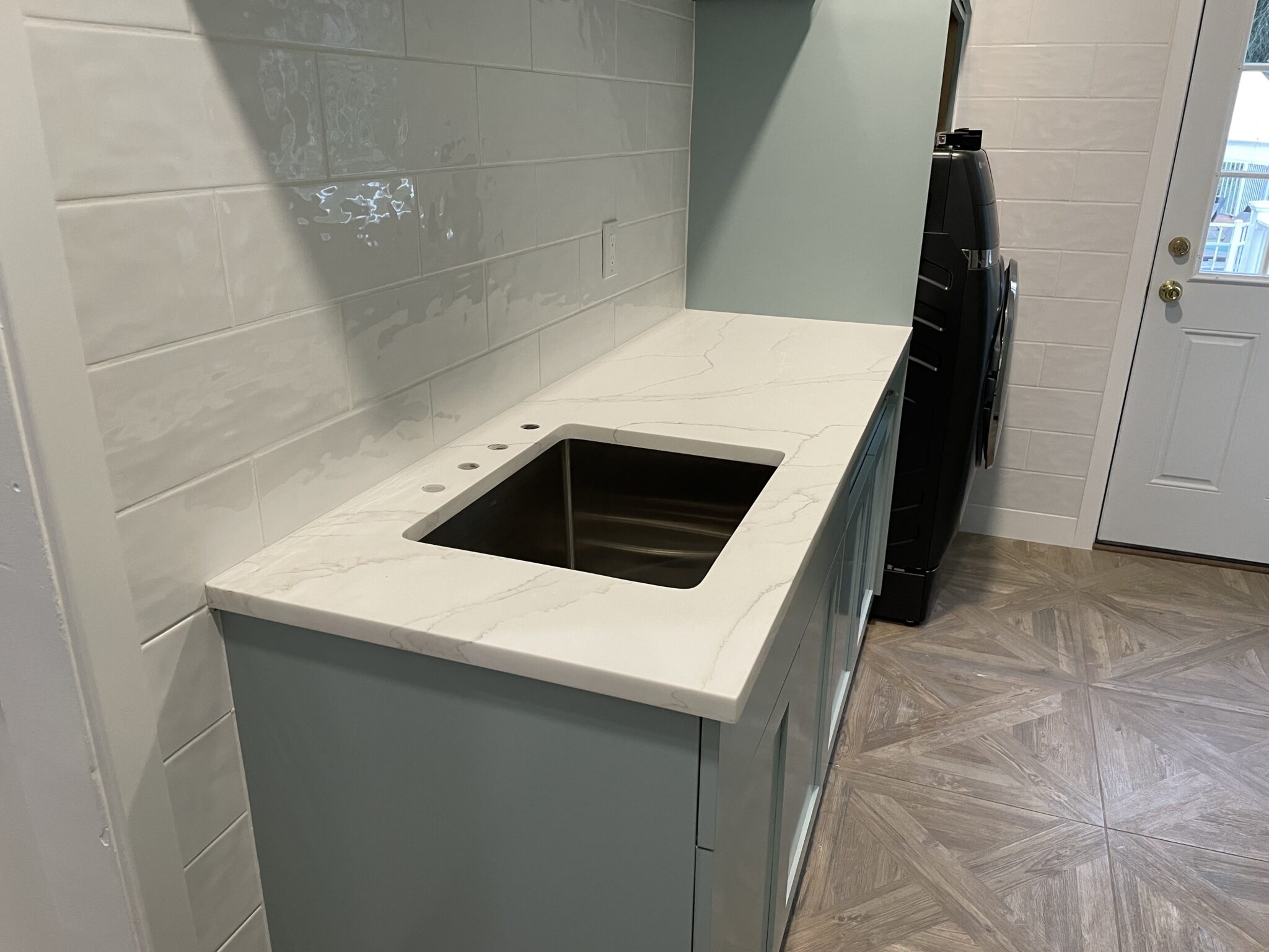 Kitchen sink with white countertop and cabinets.