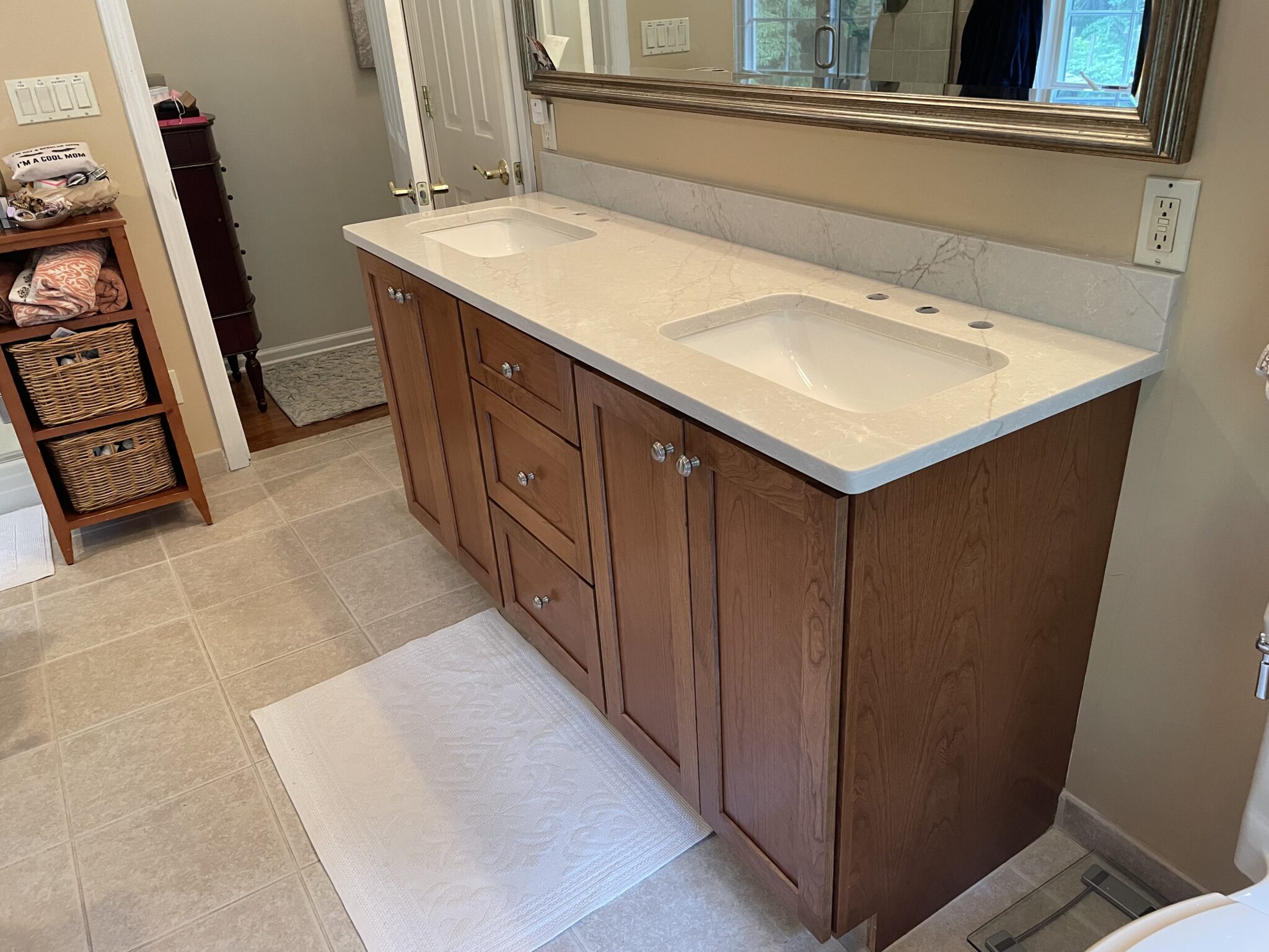 Double vanity with white countertop and cabinets.