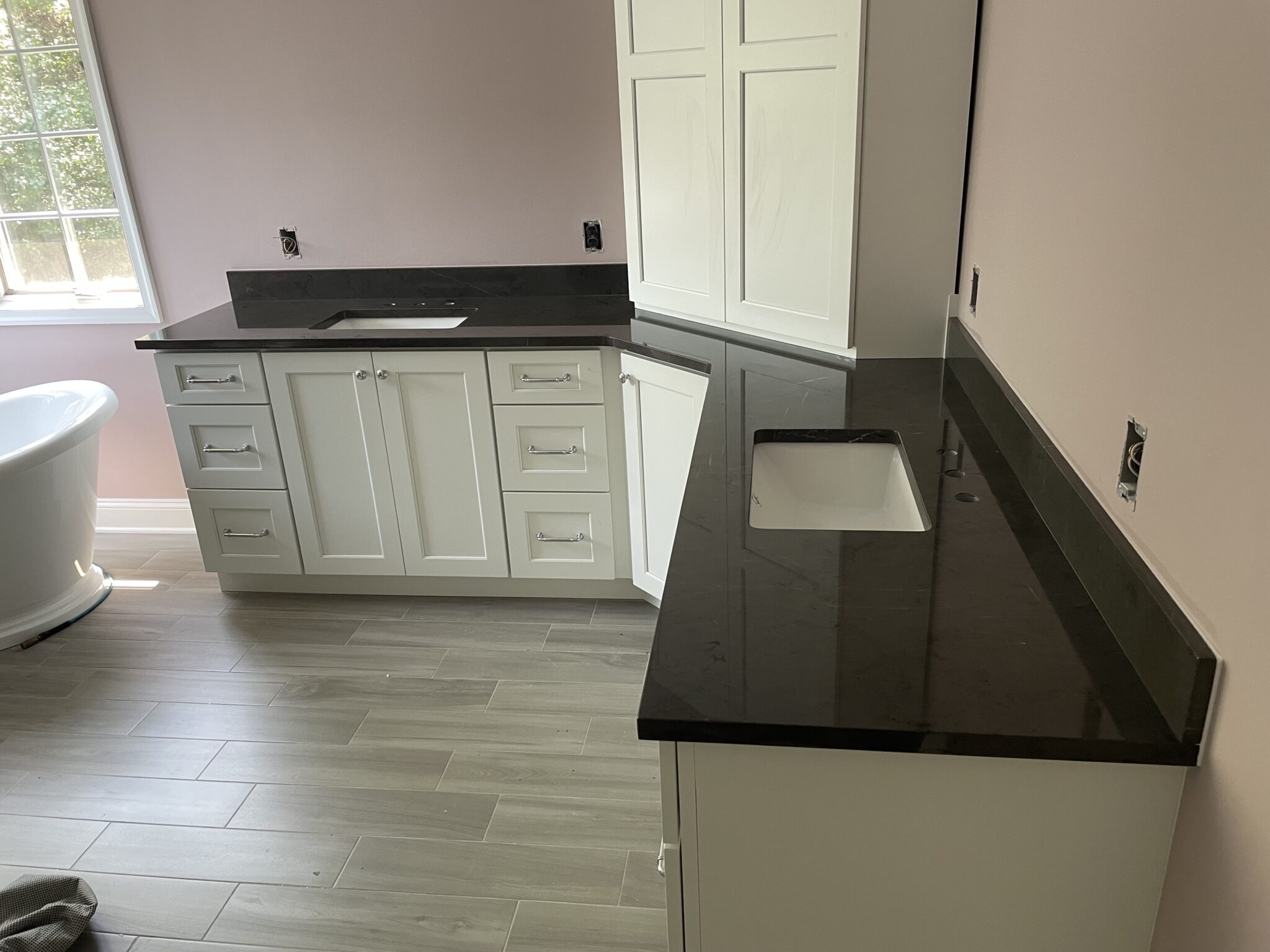 Black granite countertop with white cabinets.