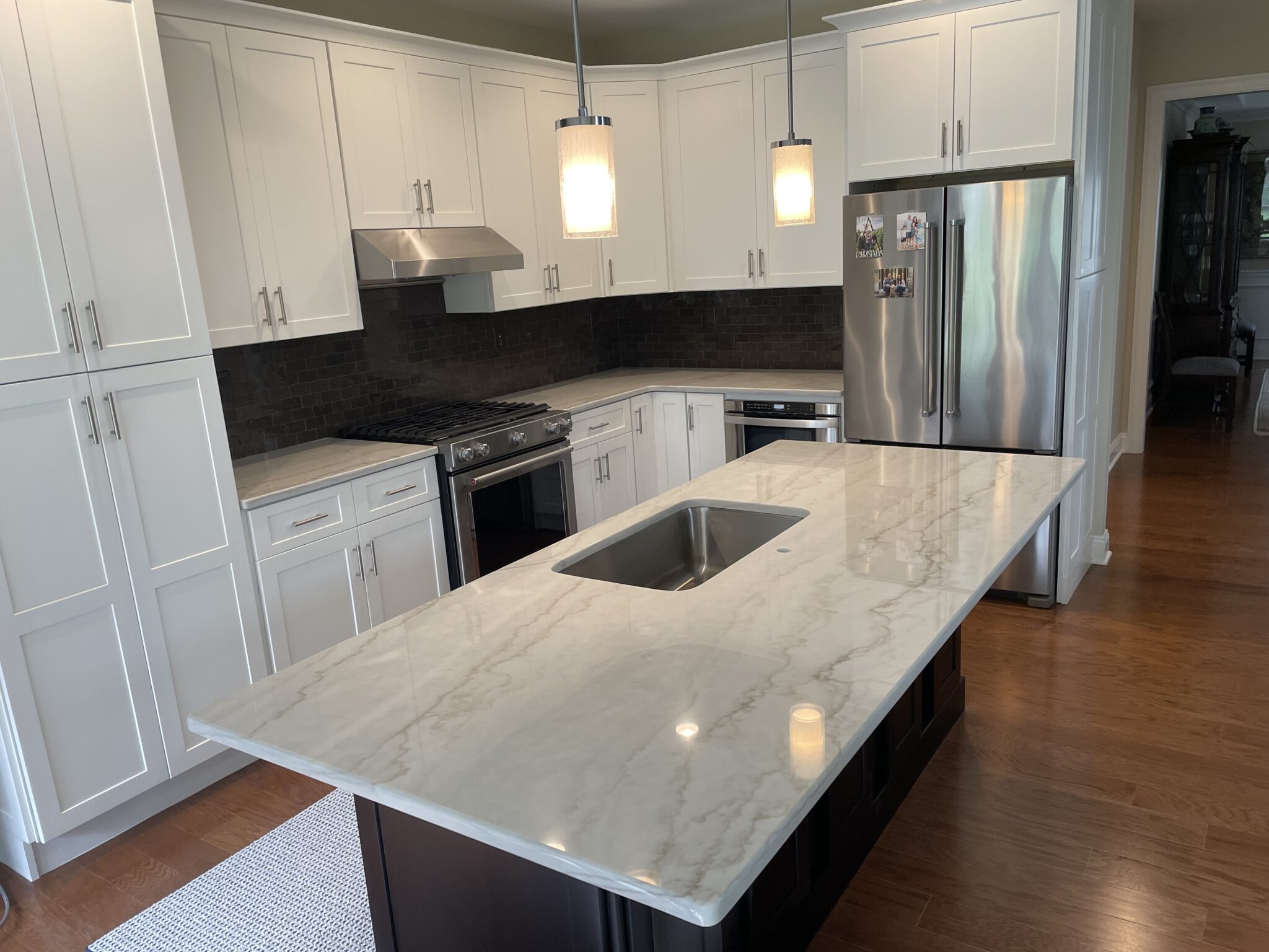 Kitchen island with white cabinets and granite countertop.