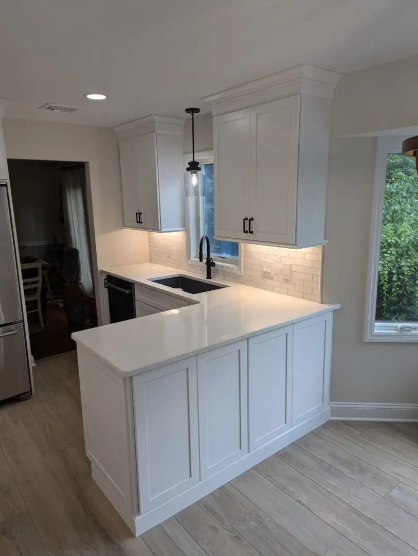 White kitchen cabinets with wood floors.