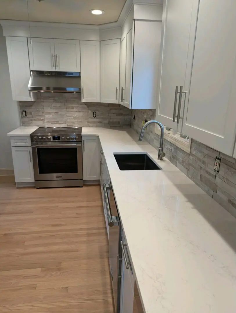 Modern kitchen with white cabinets and quartz countertop.