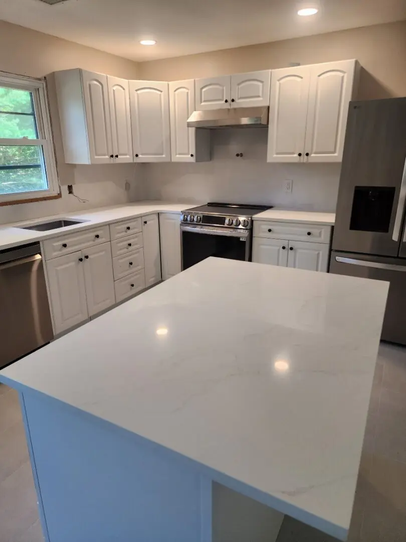 White kitchen island with marble countertop.