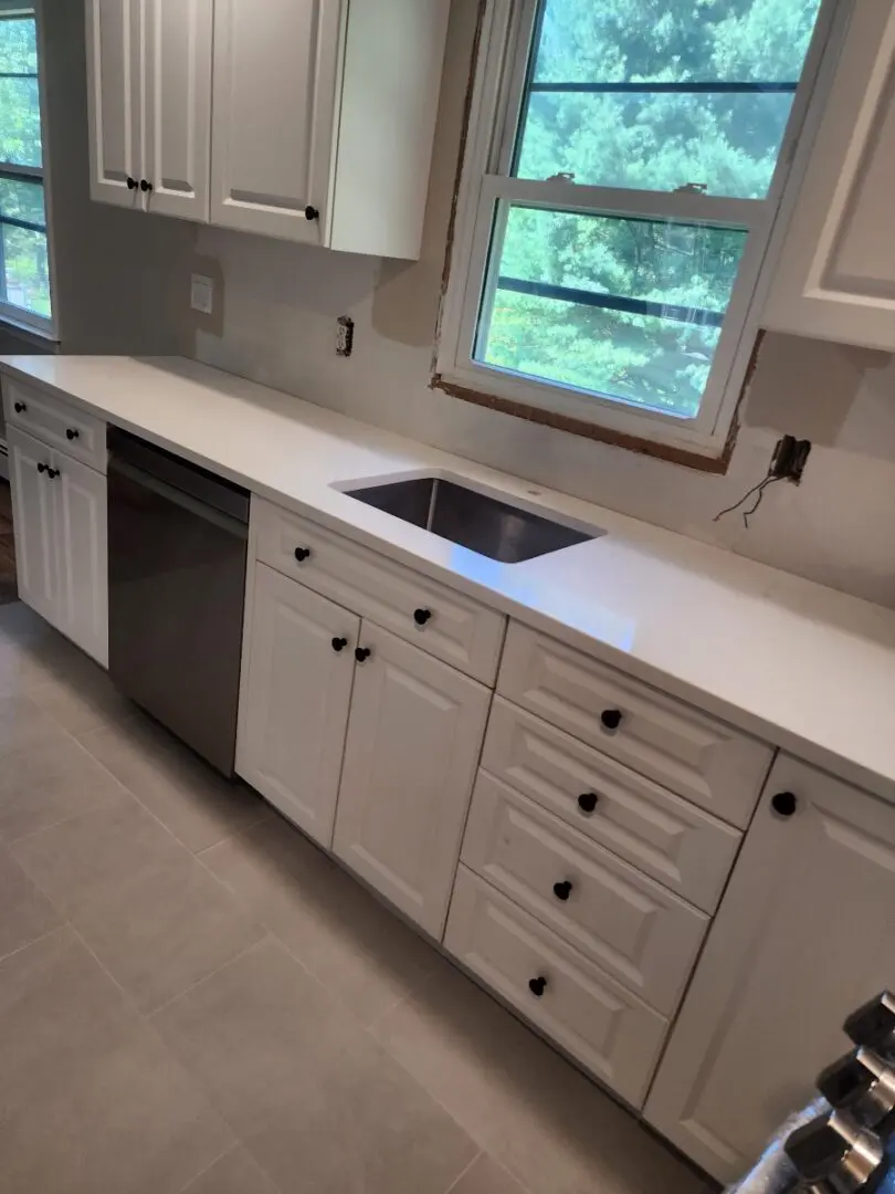 White kitchen cabinets with black knobs.