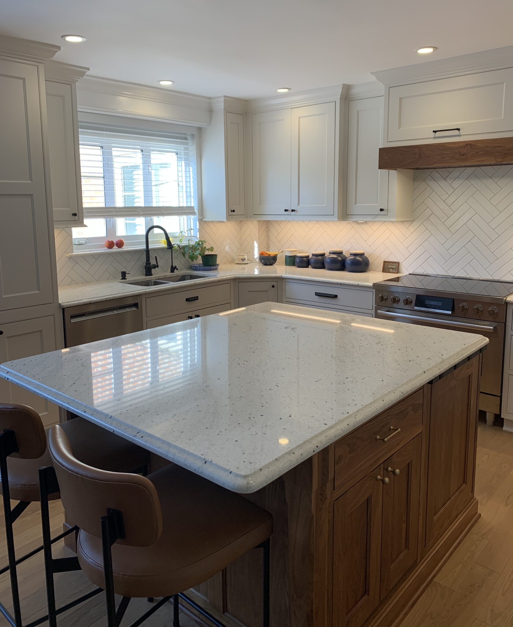 Kitchen island with white countertop and stools.