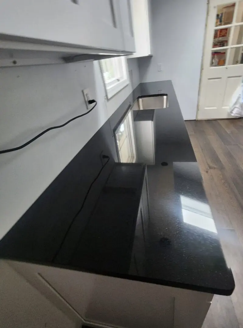 Black granite kitchen countertop with sink.