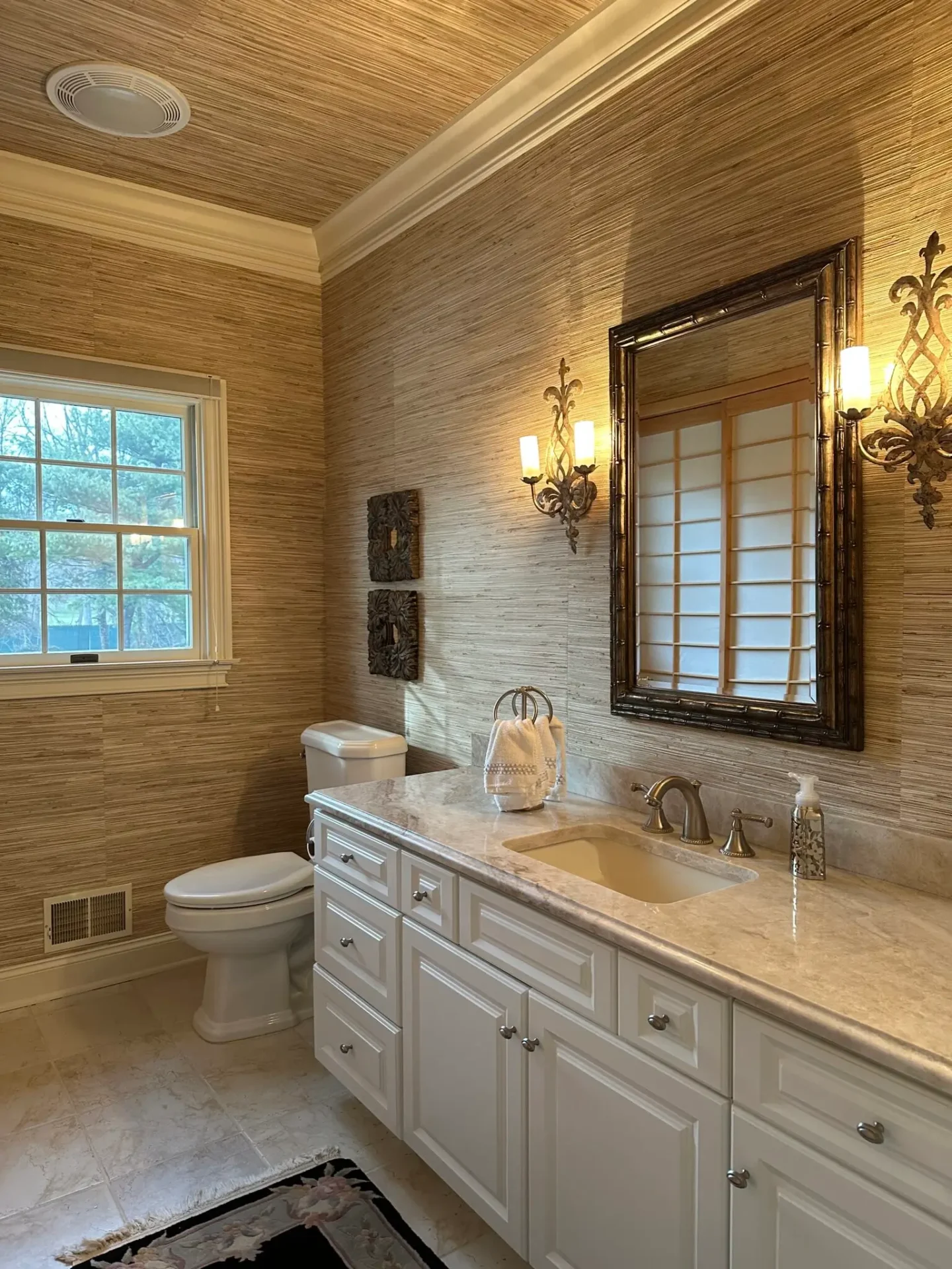 A bathroom with a toilet, sink and mirror.